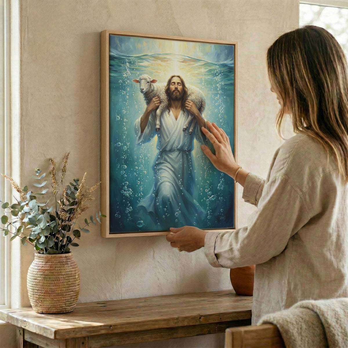 Home office desk with Jesus carrying lamb canvas art leaning on the wall for faith inspiration.