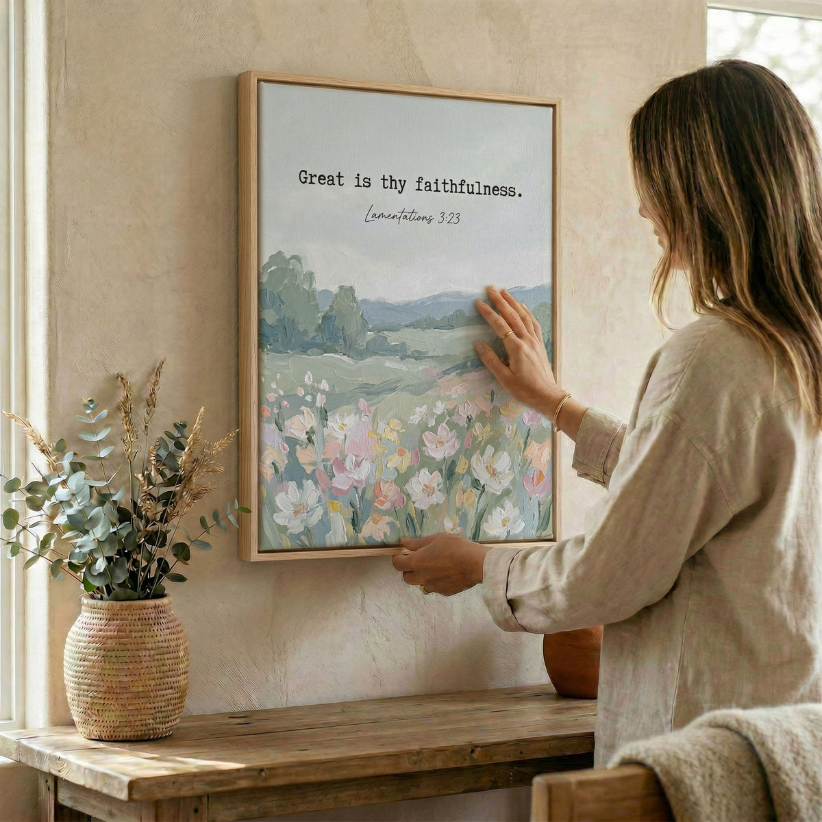 Woman hanging Lamentations 3:23 wall art in wood frame beside dried botanical arrangement