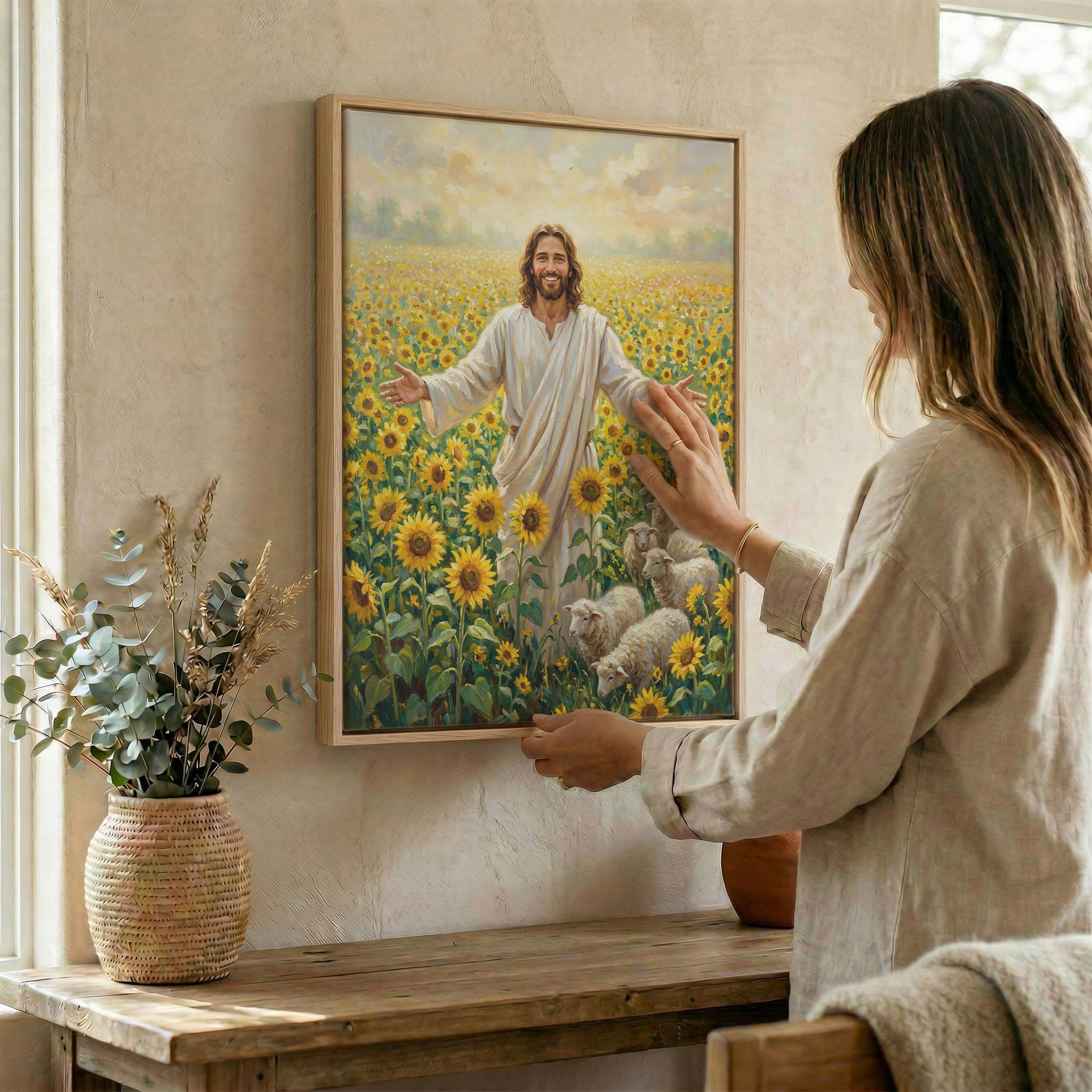 Woman hanging smiling Jesus sunflower wall art in wood frame beside dried botanical arrangement