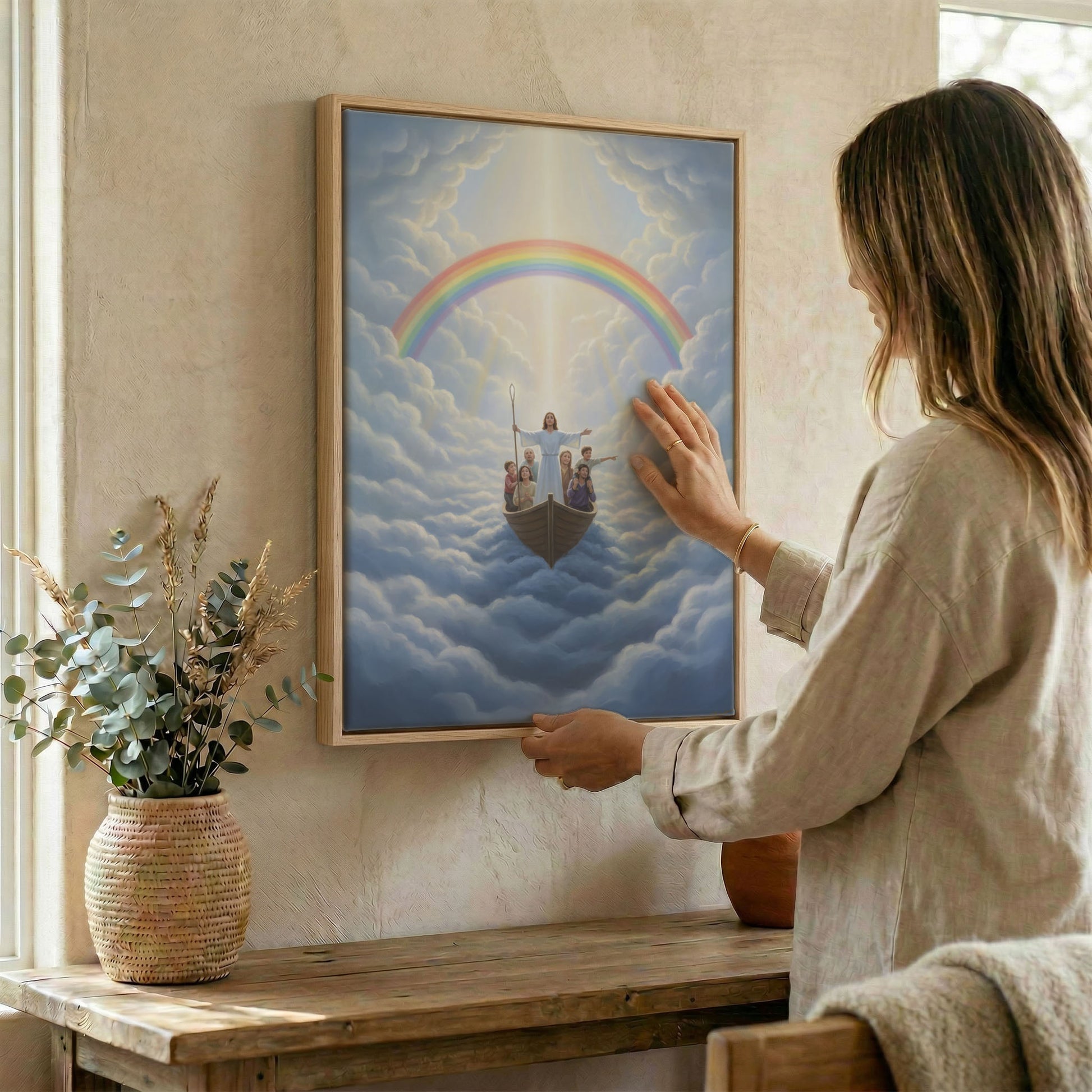 Woman placing Jesus leading family in boat rainbow wall art in wood frame on wall beside dried botanical arrangement