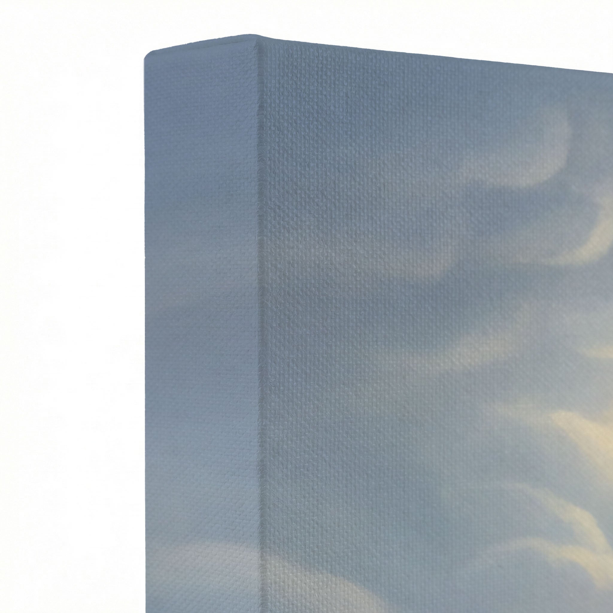 Close-up of gallery-wrapped canvas corner showing soft blue-gray sky and cloud texture on wrapped canvas edge