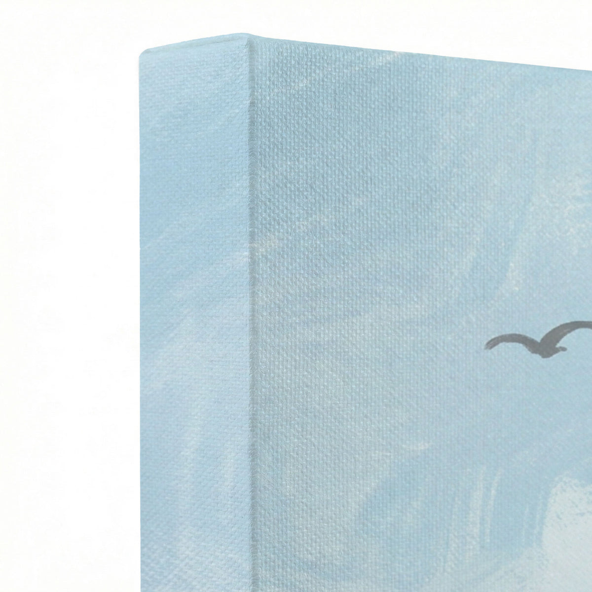 Close-up of gallery-wrapped canvas edge showing light blue sky texture and bird silhouette print detail